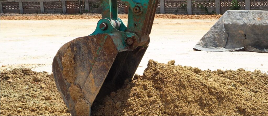 Excavator digging into dirt